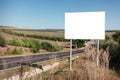 Empty billboard for advertising poster near asphalting road. Background of blue sky and beautiful nature. Royalty Free Stock Photo