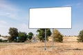 Empty billboard for advertising poster near asphalting road and village. Background of blue sky and beautiful nature. Royalty Free Stock Photo