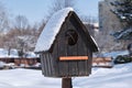 Empty bird house covered with fresh snow, on bright sunny Winter day. Close up Royalty Free Stock Photo