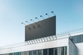 Empty black billboard with on shopping mall exterior. Blue sky background. Mock up place for your advertisement.