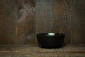 Empty black bowl on rastic wooden background. Royalty Free Stock Photo
