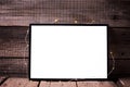 Empty black frame with twinkle light on rustic wooden backg Royalty Free Stock Photo