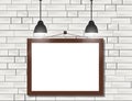 Empty black frames on white brick wall with spotlights Royalty Free Stock Photo