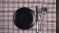 Abstract food background . Empty black plate with napkin, and cutlery.