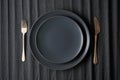 Empty black plates, fork and knife on a black background. Top view Royalty Free Stock Photo