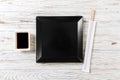 Empty black square slate plate with chopsticks for sushi on wooden background. Top view with copy space Royalty Free Stock Photo