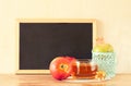 Empty blackboard, apple, honey and pomegranate. rosh hshanah concept.