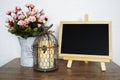 Empty Blackboard With Bird Cage And Flower In Metal Vase On Wooden Shelves