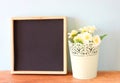 Empty blackboard and flowerpot over wooden shelf Royalty Free Stock Photo
