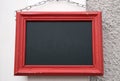 Empty blackboard hanging on a chain on the wall
