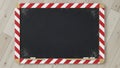 Empty blackboard with red and white striped frame on a wooden floor top view copy space Royalty Free Stock Photo