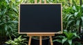 Empty Blackboard on Wooden Easel Surrounded by Lush Green Plants in a Garden Setting image Royalty Free Stock Photo