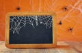 Empty blackboard on wooden table. Halloween concept