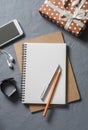 Empty blank notebook, gift box, phone on office desk top view.