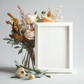 Empty blank photoframe with copy space standing on table near vase with beautiful spring flowers on white