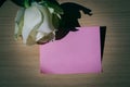 Empty blank pink paper note and white rose on wood table Royalty Free Stock Photo