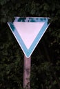 Empty blank triangular green and white sign in nature