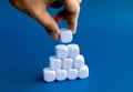 Empty blank white dice block in hand put on cube blocks stack pyramid shape construction. Royalty Free Stock Photo