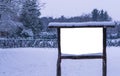 Empty and blank wooden advertisement board covered in snow, winter season in the forest, publicity billboard Royalty Free Stock Photo