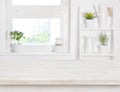 Empty bleached wooden table and kitchen window shelves blurred background