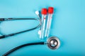 Empty Blood test tube and stethoscope with blue background Royalty Free Stock Photo