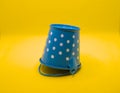 Empty blue bucket lies on a bright yellow background. Royalty Free Stock Photo