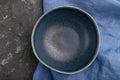 Empty blue ceramic bowl on black concrete background. Top view, close up Royalty Free Stock Photo