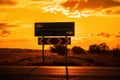 Empty blue direction crossroads road signs representing oportunities with red burning sunset background. Choose your Royalty Free Stock Photo