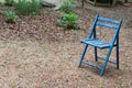 Empty blue folding chair outdoors, copy space, death grief absence concept