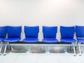 Empty blue leather airport seats on white background