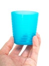Empty blue plastic glass, held in a male persons hand