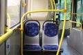 Empty blue seats and yellow handrails on the city bus. the interior of the bus without passengers Royalty Free Stock Photo