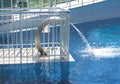 Empty blue water pool with a waterfall stream in action. Relaxation pool, spa hydrotherapy. The concept of hydromassage and Royalty Free Stock Photo