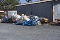 Empty blue and white fertilizer bags behind a shed