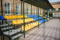 Empty blue and yellow sports seats of the grand stand at the back yard of school on the stadium Royalty Free Stock Photo