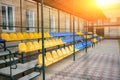 Empty blue and yellow sports seats of the grand stand at the back yard of school on the stadium Royalty Free Stock Photo