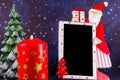 Empty board with Santa Claus and burning candle