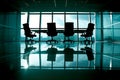An empty boardroom table with chairs arranged around,against backdrop of floortoceiling windows Royalty Free Stock Photo