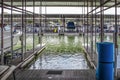 Empty boat slip in luxury boat dock at lake with other speedboats moored in distance - some up on racks and roller floater pad in