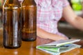 Empty bottle of beer with a sweating drop on a wooden table next to the map Royalty Free Stock Photo