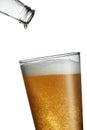 Last drop of beer from an empty bottle falling into a full glass Royalty Free Stock Photo