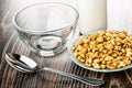 Empty bowl, bottle of yogurt, puffed wheat in saucer, spoon on wooden table