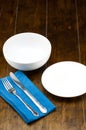 Empty bowl and dish with fork, knife, blue napery. Royalty Free Stock Photo