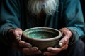 Empty bowl in old mans hands, symbolizing hunger and poverty