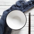 Empty bowl and pair of chopsticks on a white table Royalty Free Stock Photo