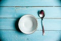 Empty bowl and spoon on weathered wooden table, top view Royalty Free Stock Photo