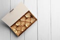 Empty box of chocolate candies on white wooden table, top view. Space for text Royalty Free Stock Photo