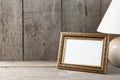 Empty brass picture frame on wooden background. Royalty Free Stock Photo