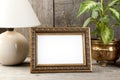 Empty brass picture frame on wooden background. Royalty Free Stock Photo