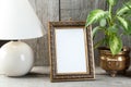 Empty brass picture frame on wooden background. Royalty Free Stock Photo